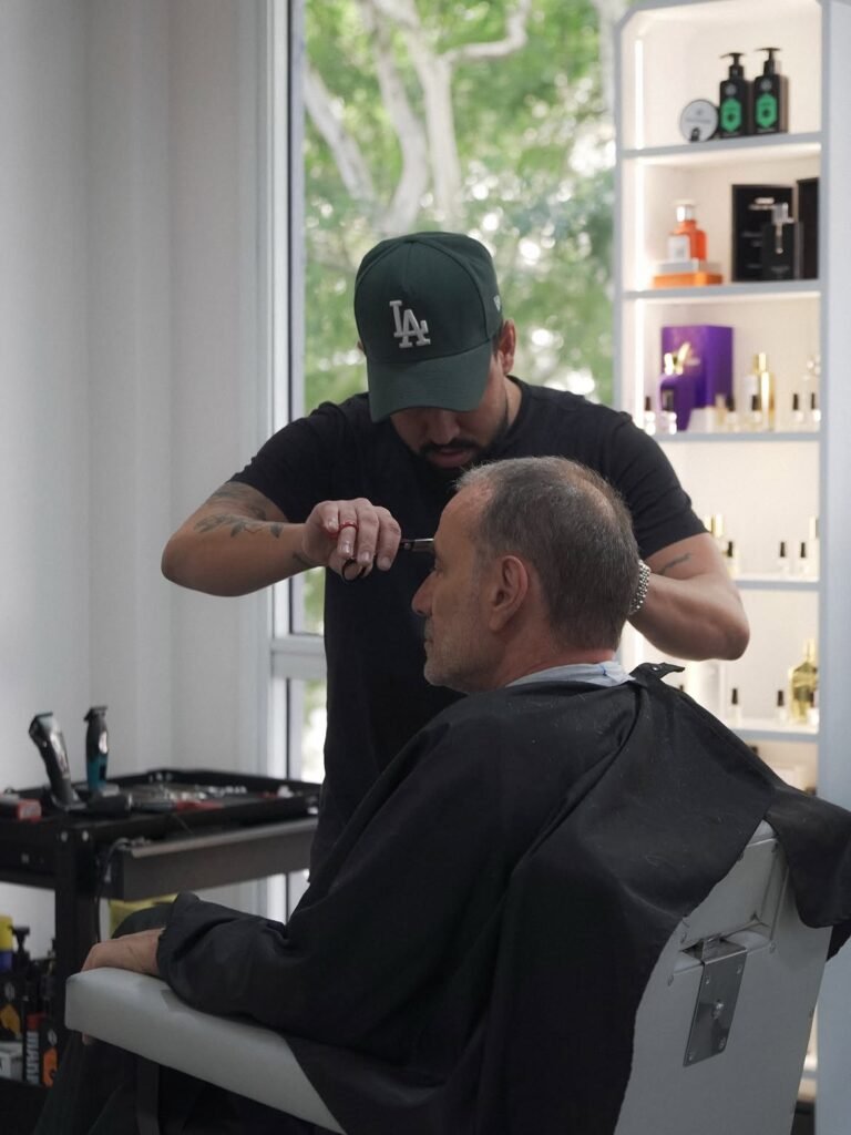 Barbeiro finalizando o corte de cabelo de um cliente na cadeira do Hope Studio