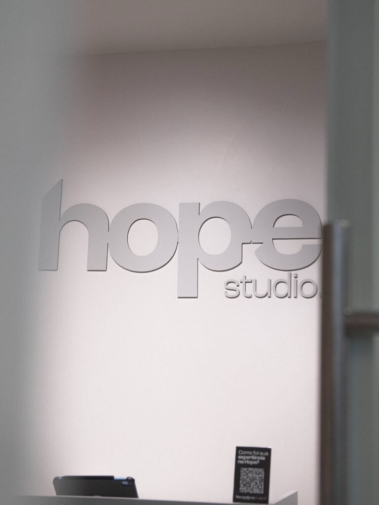 Letreiro Hope Studio aplicado na parede da recepcao